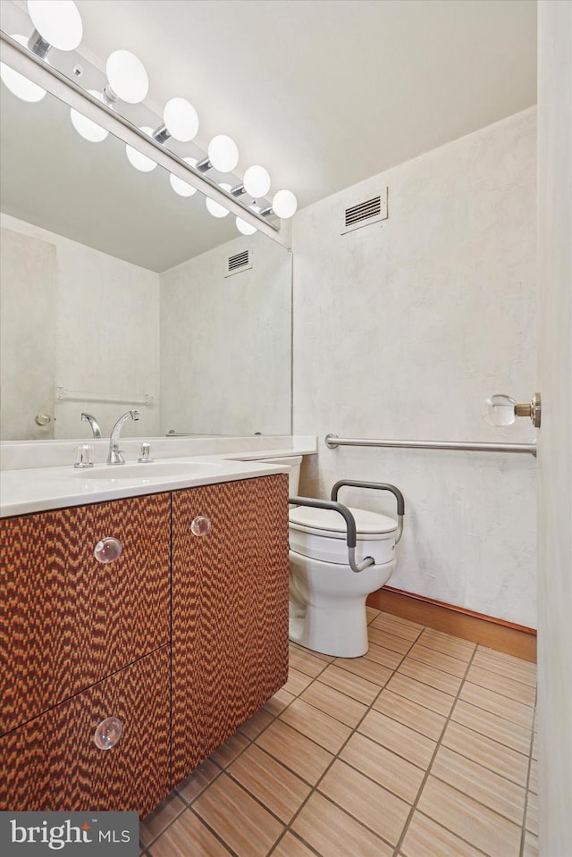 bathroom featuring toilet, vanity, and visible vents