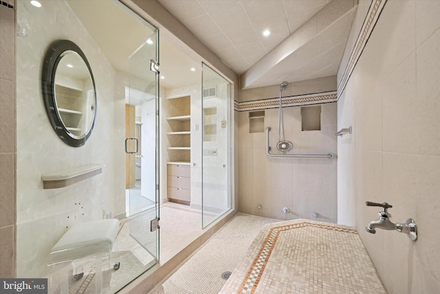 full bath featuring visible vents, a shower stall, tile walls, and recessed lighting