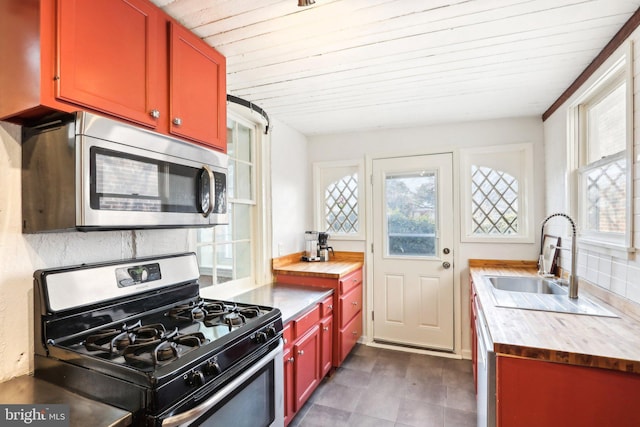 kitchen featuring decorative backsplash, butcher block counters, wood ceiling, appliances with stainless steel finishes, and a sink