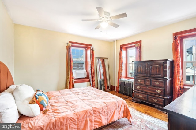 bedroom with radiator, ceiling fan, and wood finished floors