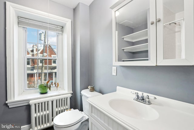 bathroom with radiator, toilet, and vanity