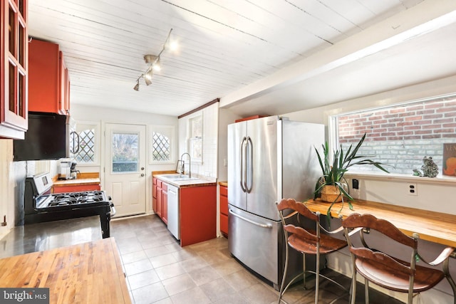 kitchen with freestanding refrigerator, a sink, white dishwasher, track lighting, and gas stove