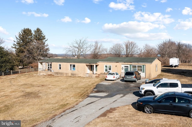 view of front of home featuring fence and a front lawn