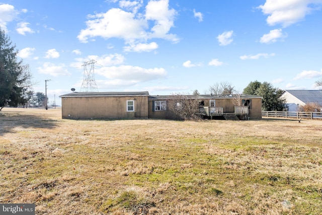 back of property with a yard and fence