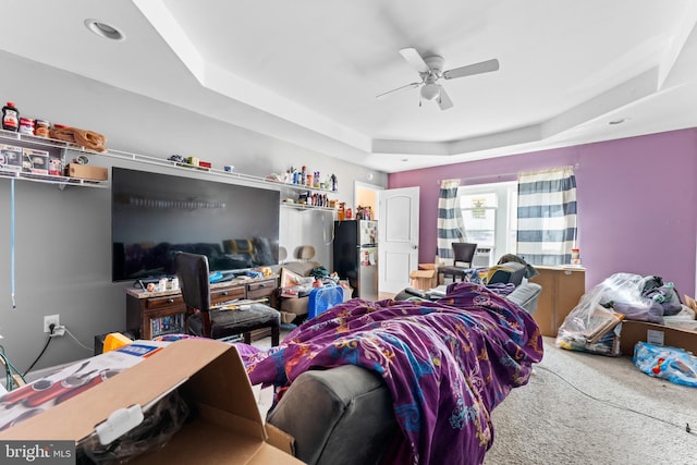 carpeted bedroom featuring a raised ceiling, a ceiling fan, and freestanding refrigerator