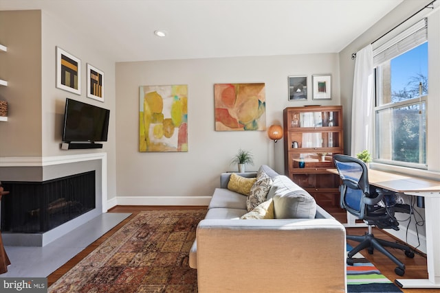 living area featuring recessed lighting, baseboards, dark wood finished floors, and a multi sided fireplace