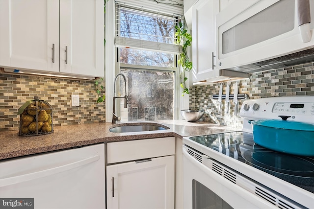 kitchen featuring white appliances, a sink, and white cabinetry