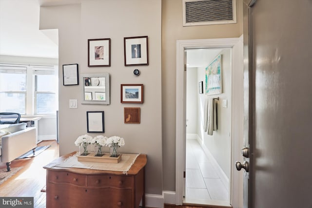 hallway with visible vents and baseboards