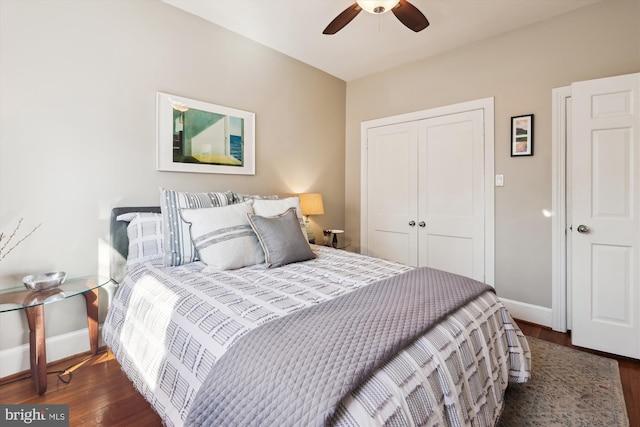 bedroom with dark wood-style floors, a closet, baseboards, and a ceiling fan