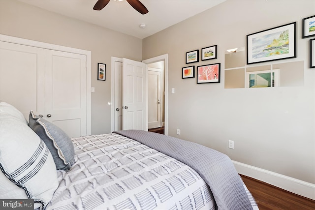 bedroom with a closet, wood finished floors, a ceiling fan, and baseboards