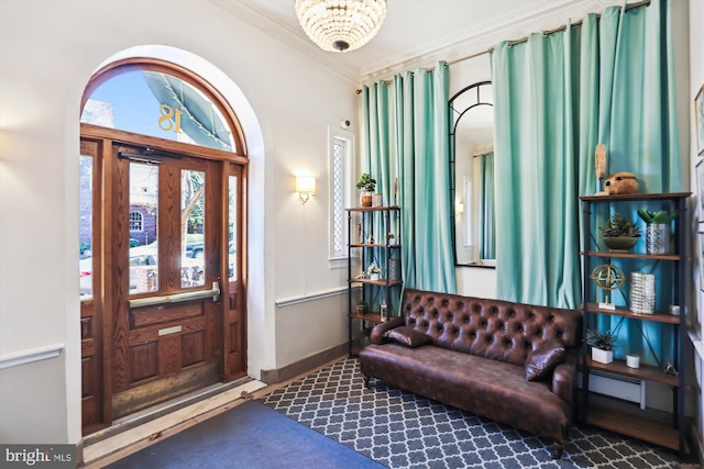 foyer entrance featuring baseboards, baseboard heating, and crown molding