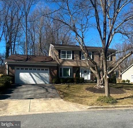 view of front of house featuring driveway, a front yard, and a garage