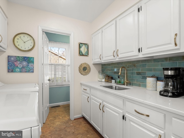 bar featuring baseboards, tasteful backsplash, a sink, and visible vents
