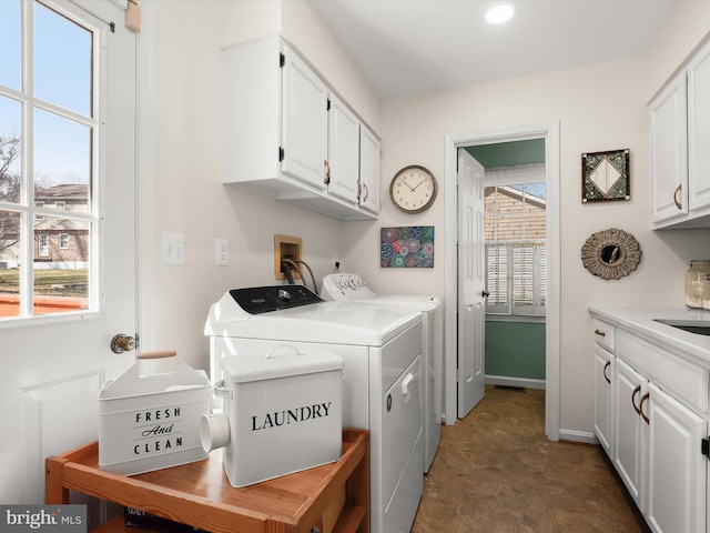 washroom with baseboards, independent washer and dryer, recessed lighting, and cabinet space