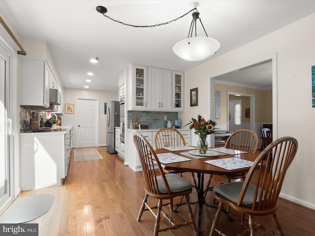 dining space with recessed lighting, light wood-style floors, and ornamental molding
