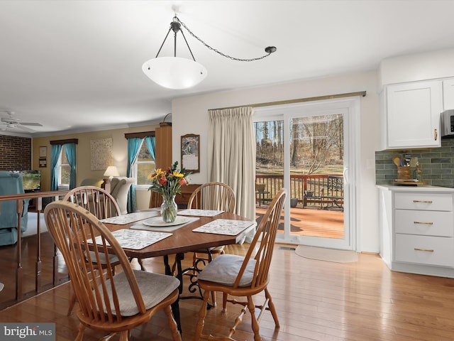 dining area with light wood-style flooring and a ceiling fan