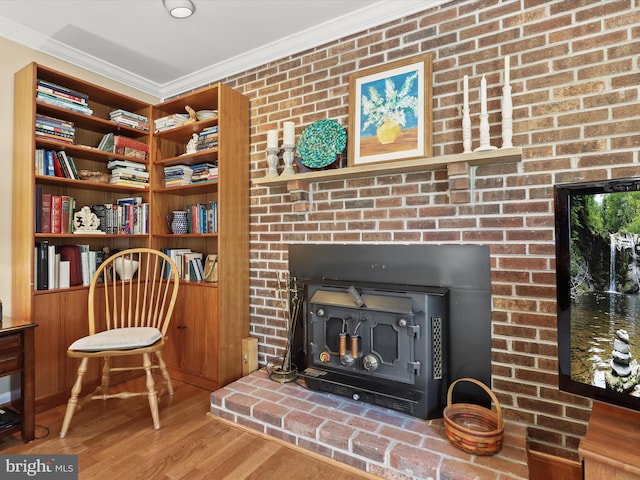 sitting room with wood finished floors, a fireplace, and ornamental molding