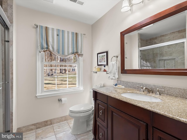bathroom with visible vents, vanity, a shower stall, and toilet