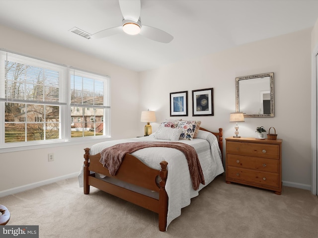 carpeted bedroom with baseboards, a ceiling fan, and visible vents