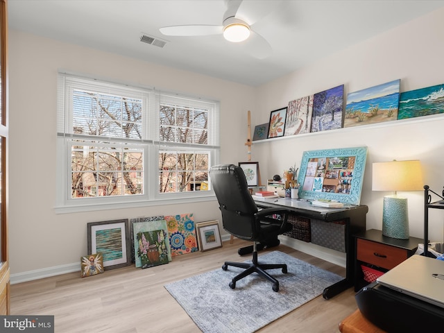 office space featuring wood finished floors, visible vents, a ceiling fan, and baseboards