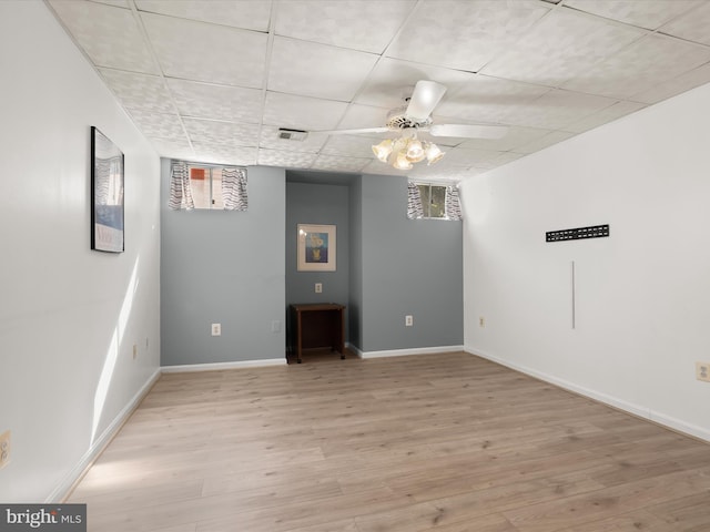 basement with baseboards, a drop ceiling, visible vents, and light wood-type flooring