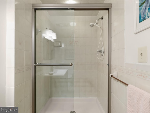 bathroom with tile walls and a stall shower