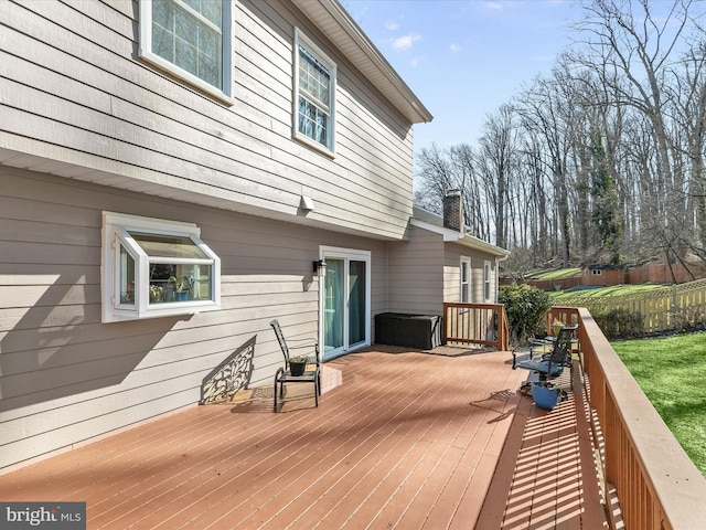 wooden deck featuring a lawn and fence