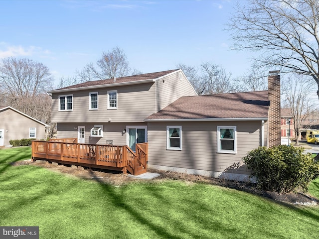 back of property with a chimney, a wooden deck, a yard, and a shingled roof
