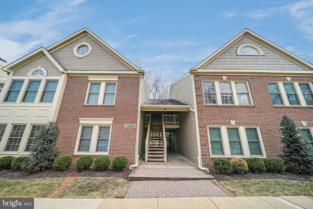 view of front of house with brick siding and stairway