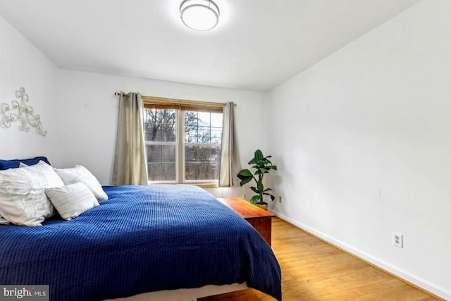 bedroom featuring baseboards and wood finished floors