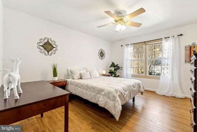 bedroom with a ceiling fan, baseboards, and hardwood / wood-style floors