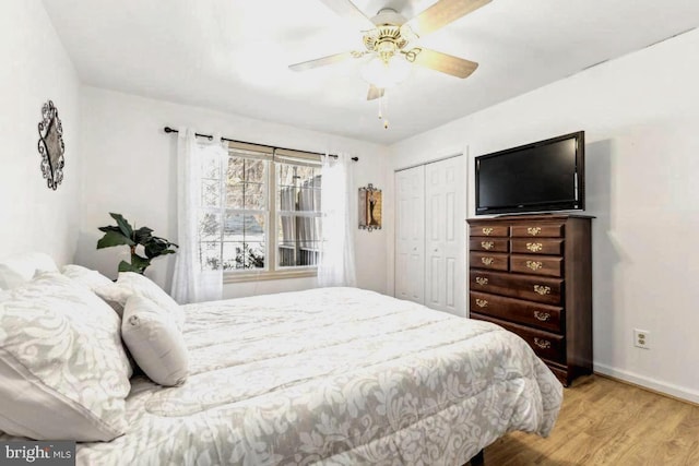 bedroom with a closet, wood finished floors, a ceiling fan, and baseboards