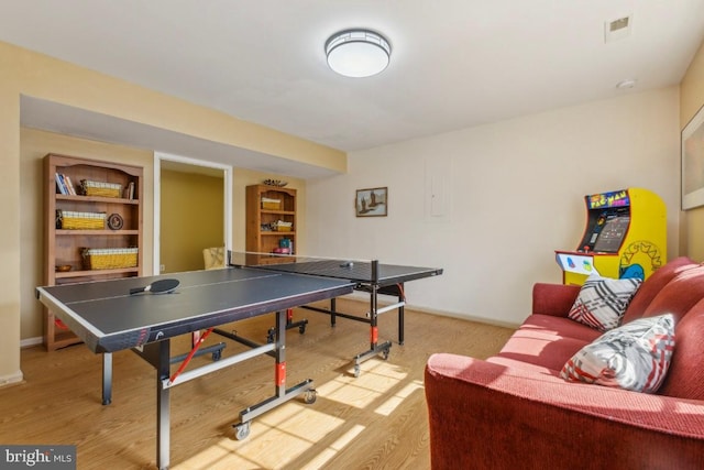 rec room with light wood-style flooring, visible vents, and baseboards