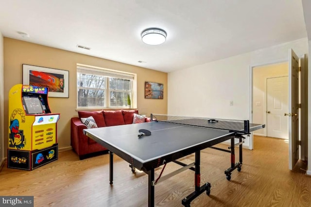 rec room with light wood finished floors, visible vents, and baseboards