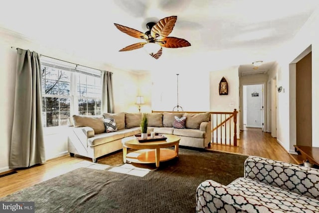 living area with ceiling fan, light wood finished floors, visible vents, and baseboards