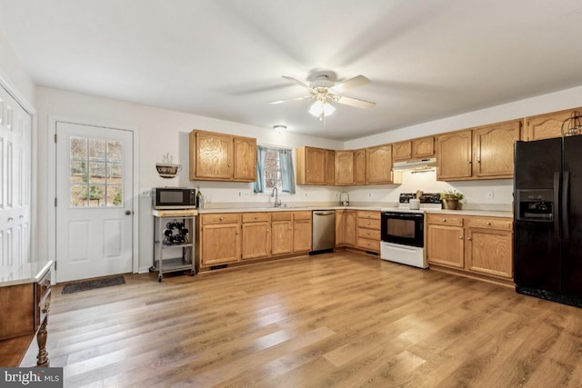 kitchen with range with electric stovetop, light countertops, light wood-style flooring, stainless steel dishwasher, and black fridge