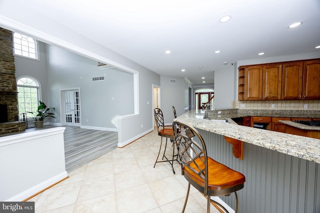 2729 Hollow View Dr, Finksburg, MD 21048 - kitchen featuring a peninsula, a sink, light stone countertops, recessed lighting, and a kitchen breakfast bar