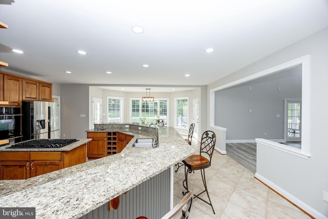 2729 Hollow View Dr, Finksburg, MD 21048 - kitchen with black appliances, a sink, a large island, brown cabinetry, and recessed lighting