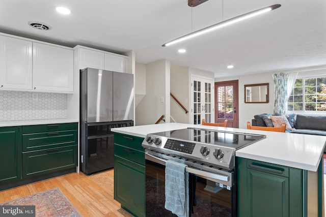 kitchen with green cabinetry, visible vents, light wood-style flooring, appliances with stainless steel finishes, and white cabinetry