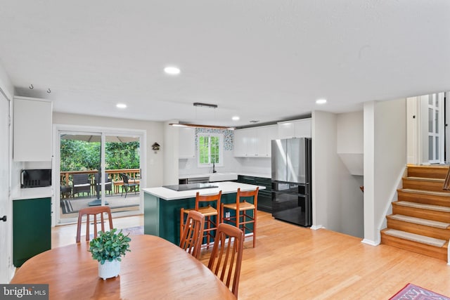 dining room with stairs, light wood finished floors, and recessed lighting