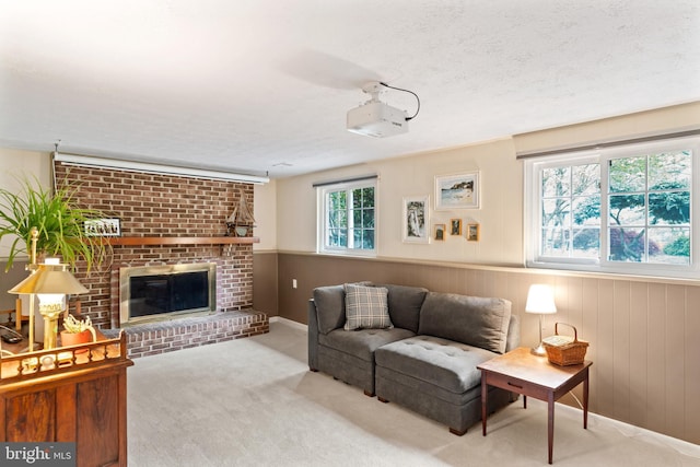 carpeted living room featuring a fireplace and a wainscoted wall