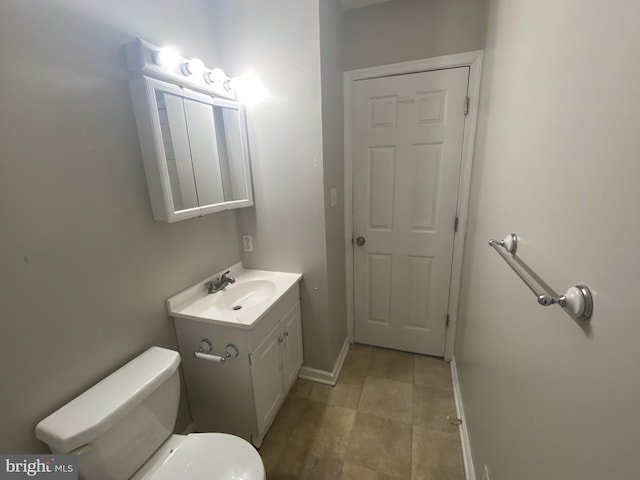 bathroom with vanity, toilet, and baseboards