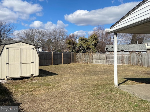 view of yard with a fenced backyard, a storage unit, and an outdoor structure