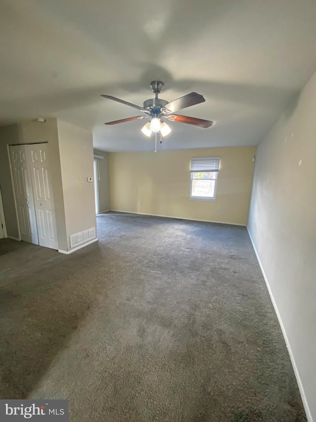 empty room featuring carpet, visible vents, baseboards, and ceiling fan