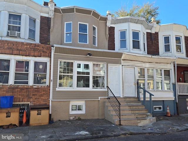 townhome / multi-family property with entry steps, cooling unit, and brick siding