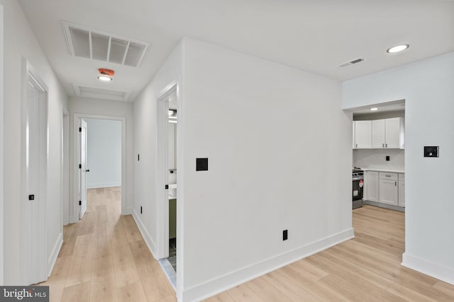 hall featuring visible vents, recessed lighting, baseboards, and light wood-style floors