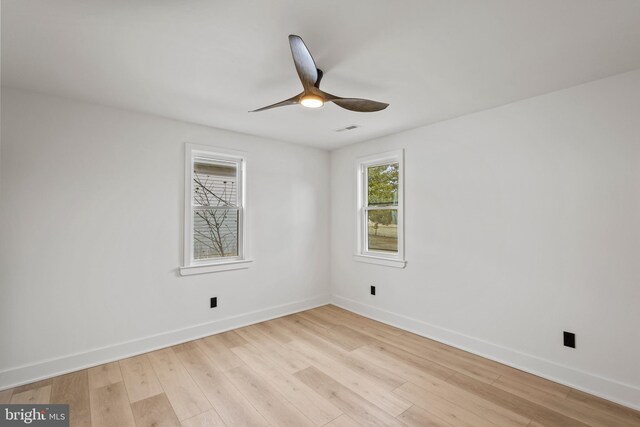 spare room featuring visible vents, light wood-style flooring, baseboards, and a ceiling fan