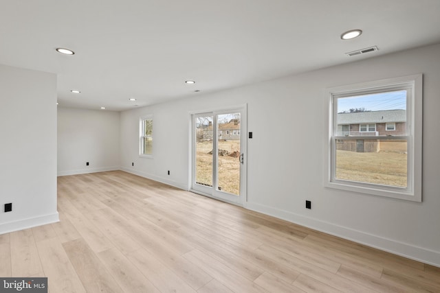 empty room with recessed lighting, visible vents, light wood finished floors, and baseboards