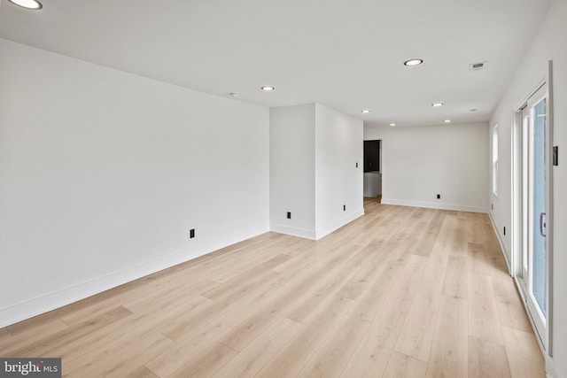 spare room with recessed lighting, baseboards, and light wood-style floors