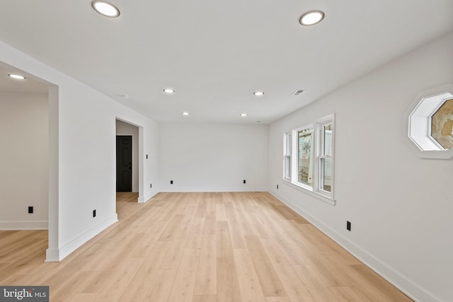 empty room with visible vents, recessed lighting, light wood-type flooring, and baseboards